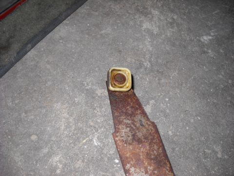 1993 Ford C-150 (Centurion Conversions) - A close-up of a corroded metal component with a plastic fitting, resting on a rough surface.