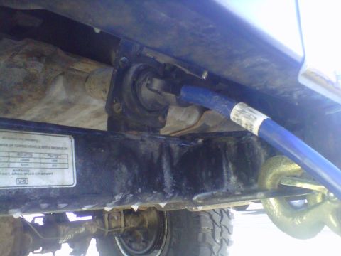 1994 Ford F-150 - A blue hose is connected to a tow hook assembly on the underside of a truck's frame.