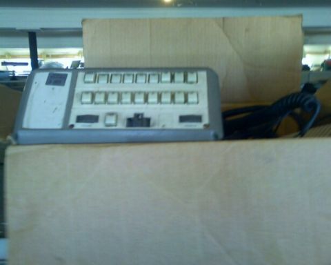 2001 Ford Crown Victoria - A control panel with numerous buttons and a coiled cable is partially visible, situated within cardboard packaging.