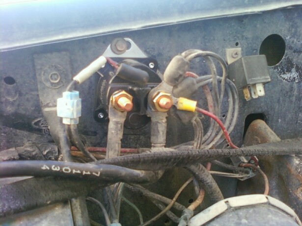 Fender-mounted starter solenoid with copper stud terminals and wiring in an engine bay