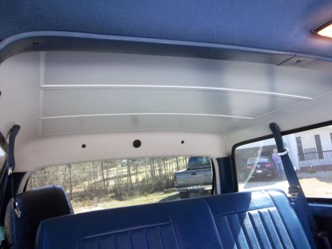 1995 Ford Bronco - View from the back seat of an older vehicle, looking out at other vehicles and trees.