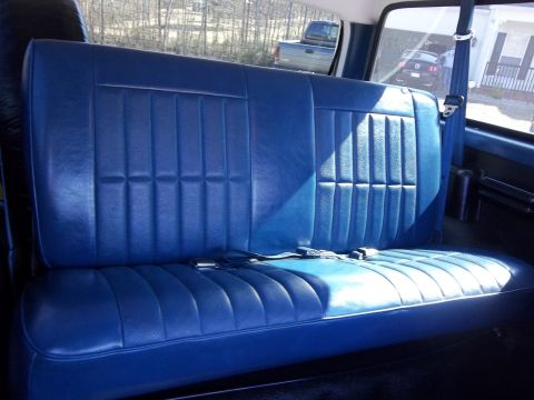 1995 Ford Bronco - Interior view of a vehicle's blue bench seat, with other vehicles seen through the windows.