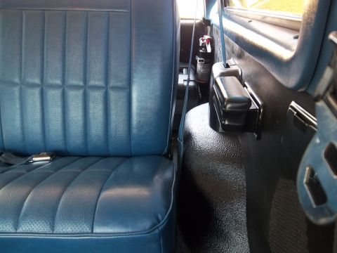 1995 Ford Bronco - Interior view shows blue vinyl seats and a fire extinguisher mounted behind the driver's seat.