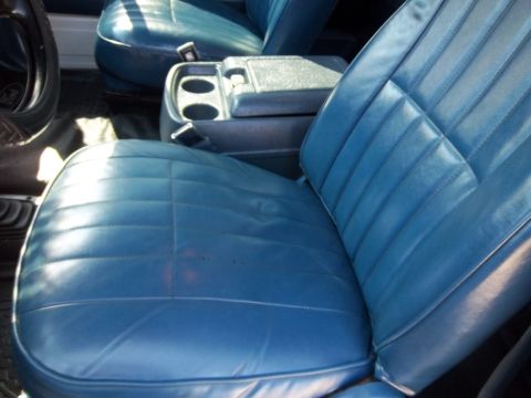 1995 Ford Bronco - Interior view of a car's blue vinyl seats and center console.