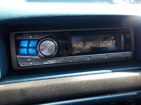1995 Ford Bronco - Close-up of a car's interior showing the dashboard stereo system with a digital display.
