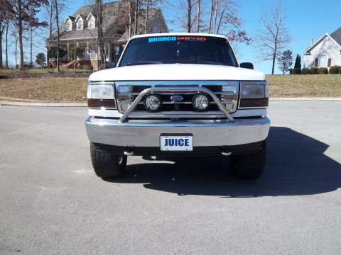 1995 Ford Bronco - Front view of a white Ford Bronco with aftermarket accessories, parked on asphalt.