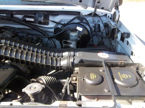 1995 Ford Bronco - Engine bay of a 1995 Ford Bronco, showing various components and fluid reservoirs.