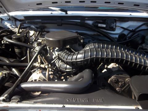 1995 Ford Bronco - Close-up view of the engine compartment, showing various mechanical components and hoses.