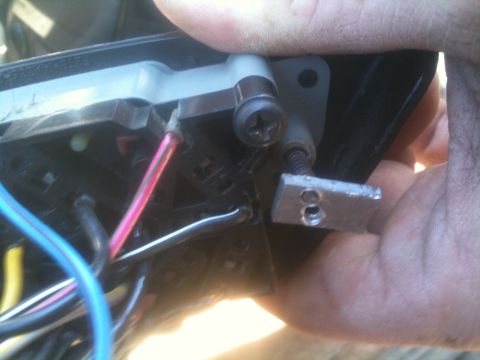 1993 Ford Bronco - A hand is shown manipulating an automotive electrical component with visible wires and screws.