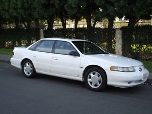 1993 Ford Taurus - 1993 Ford Taurus sedan seen from the front three-quarter view on a street.