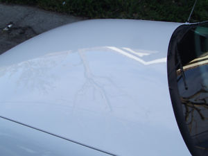1993 Ford Taurus - Close-up of a white car's hood, showing some subtle markings.