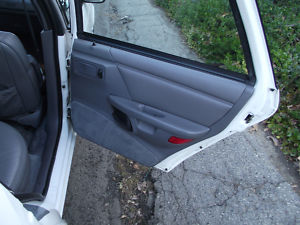 1993 Ford Taurus - Interior view of a white car's door panel, showing gray fabric and plastic trim.