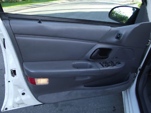 1993 Ford Taurus - Interior view of a car's gray door panel, showing the window controls and a small red reflector near the bottom.