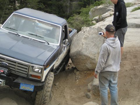 1986 Ford Bronco - A 1986 Ford Bronco is carefully maneuvered around a massive boulder during an off-road excursion.