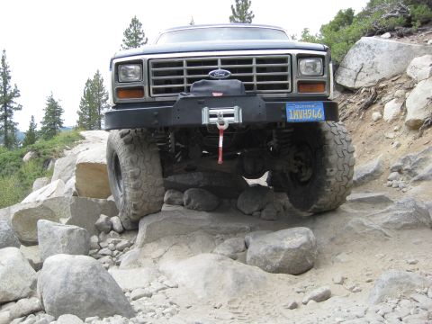 1986 Ford Bronco - This modified Ford Bronco is navigating a difficult rocky terrain, its off-road capabilities.