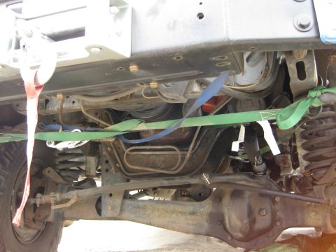1986 Ford Bronco - Undercarriage detail showing suspension and winch, secured with straps.