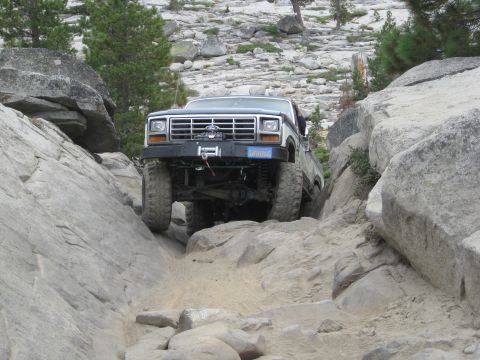1986 Ford Bronco - A Ford Bronco tackles a challenging rocky terrain, demonstrating its off-road capabilities.