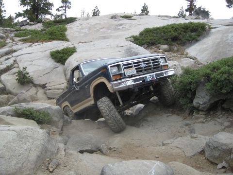 1986 Ford Bronco - This 1986 Ford Bronco is tackling a challenging off-road course with large rocks.