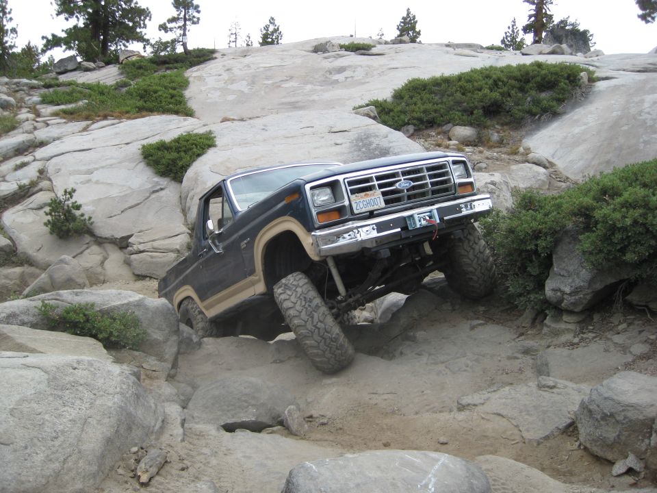 1986 Ford Bronco navigating a rocky trail, front wheels turned