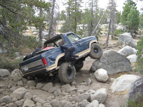 1986 Ford Bronco - This 1980s Ford Bronco navigates a challenging rocky trail, demonstrating its off-road capabilities.