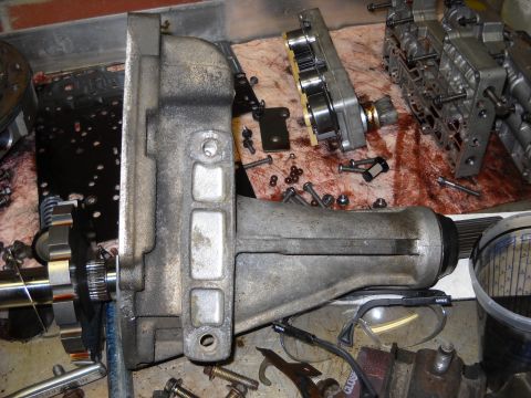 1993 Ford C-150 (Centurion Conversions) - Automatic transmission parts laid out for rebuild, with various fasteners and tools visible.