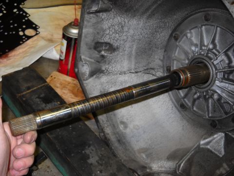 1993 Ford C-150 (Centurion Conversions) - Close-up of a transmission input shaft being held, with the transmission housing in the background.