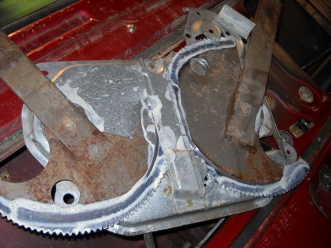 1993 Ford C-150 (Centurion Conversions) - A close-up view of a rusty window regulator mechanism with a toothed track.