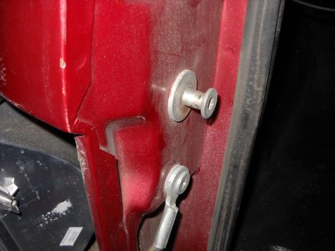 1993 Ford C-150 (Centurion Conversions) - Close-up view of a red door latch mechanism with visible metal fasteners and a rubber seal.