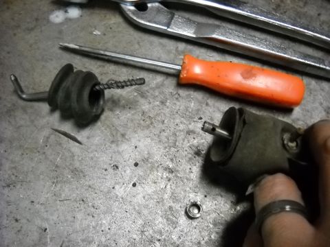 1993 Ford C-150 (Centurion Conversions) - Close-up of an automotive part and tools on a workbench. The part appears to be a vacuum actuator or similar component.