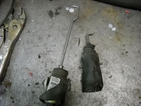 1993 Ford C-150 (Centurion Conversions) - Two automotive door lock actuators are shown on a workbench, one with a visible Ford label.