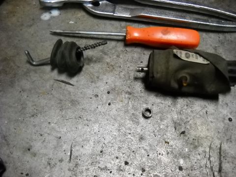 1993 Ford C-150 (Centurion Conversions) - Disassembled door lock actuator components and tools laid out on a metal surface.