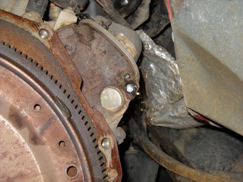 1993 Ford C-150 (Centurion Conversions) - Close-up view of a vehicle's engine starter motor and flywheel assembly, showing signs of wear and wear.