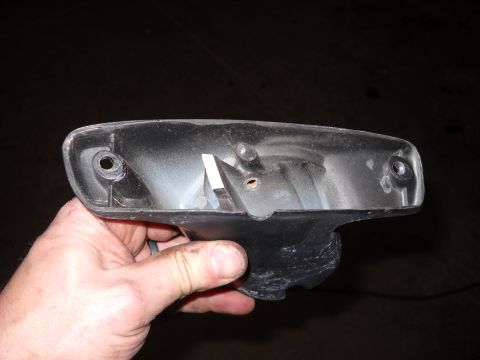 1993 Ford C-150 (Centurion Conversions) - A person holds a detached black plastic housing for a vehicle's door mirror, showing its internal structure and mounting points.