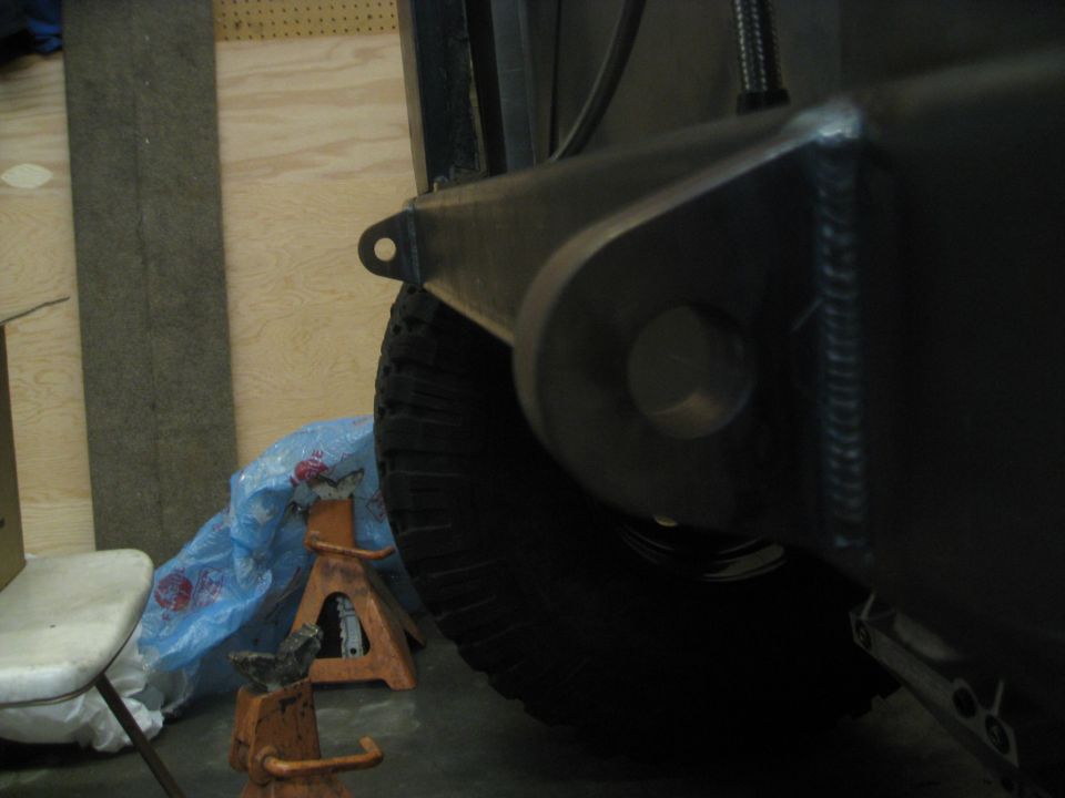 Jeep YJ frame with welded bracket and tire on jack stands