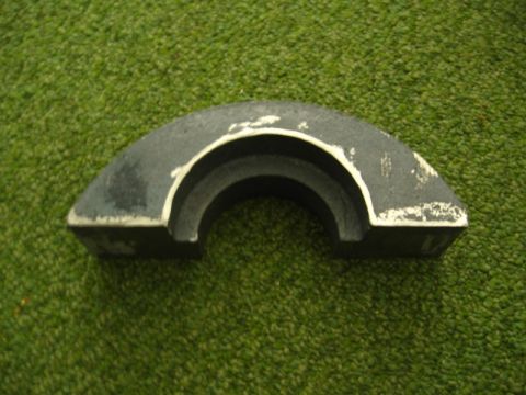 1972 Ford Ranchero - A metal automotive part sits on a green, carpet-like surface. The part is curved and shows signs of wear.