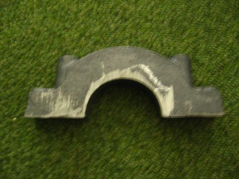 1972 Ford Ranchero - A metal automotive part is shown against a green textured background, with visible tool marks.
