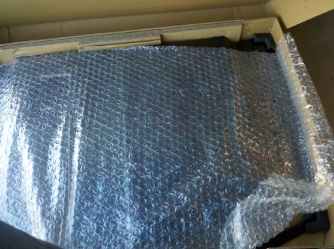 1995 Ford Bronco - A car hood is packaged in bubble wrap and placed within a cardboard box for shipping.