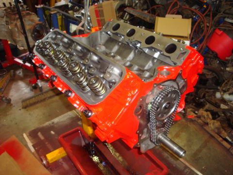 1989 Ford Bronco - Close-up view of an orange V8 engine block, showing the timing chain and valve train components during a rebuild.