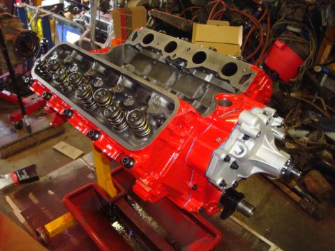1989 Ford Bronco - Engine block assembly with valve train components and water pump attached, displayed on a stand in a workshop.