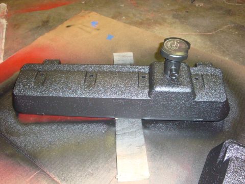 1989 Ford Bronco - A freshly painted engine valve cover sits on a work surface, ready for installation.