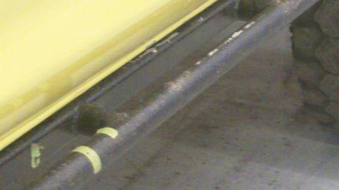 1978 Ford Bronco - Close-up view of a yellow vehicle's body panel and frame rail, with visible wear and tape markings.