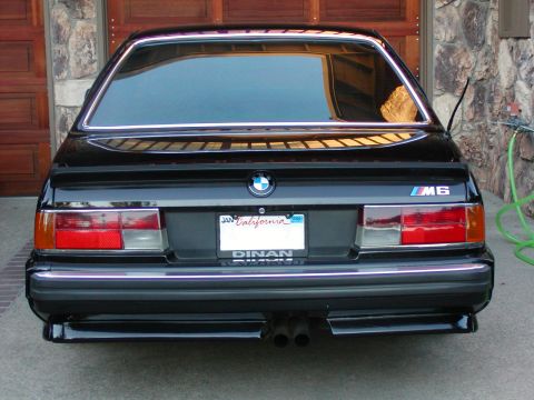 1992 Mercury Grand Marquis - Rear view of a black BMW M6 with custom Dinan badging and a California license plate.