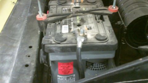 1978 Ford Bronco - Close-up of a car battery, showing a red warning sticker and a date code of October 2010.