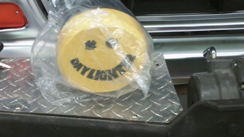 1978 Ford Bronco - A yellow smiley face accessory with the word 'DAYLIGHT' is shown in its original plastic packaging.