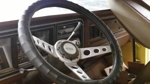 1978 Ford Bronco - The interior of a 1978 Ford Bronco features an aftermarket steering wheel and dashboard details.
