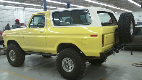 1978 Ford Bronco - This lifted 1978 Ford Bronco is parked inside a garage with a white hardtop and large off-road tires.