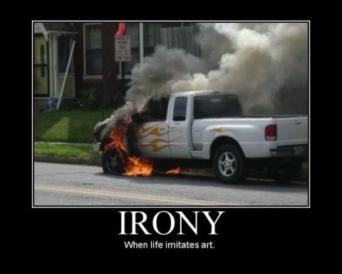 1988 Ford Bronco - A white pickup truck is seen on fire, emitting thick smoke. The image is captioned with 'Irony'.