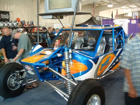 1993 Ford Taurus - A custom dune buggy is displayed indoors with a TV overhead and other vehicles in the background.