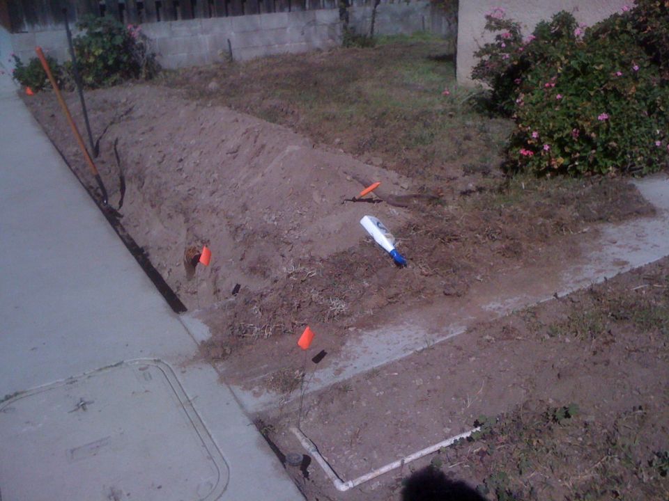 Construction site with orange flags, shovel, and a white marker
