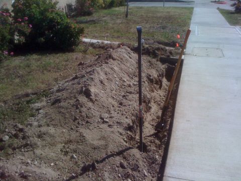 1968 Ford Mustang - A trench has been dug along a sidewalk, with surveying equipment visible.